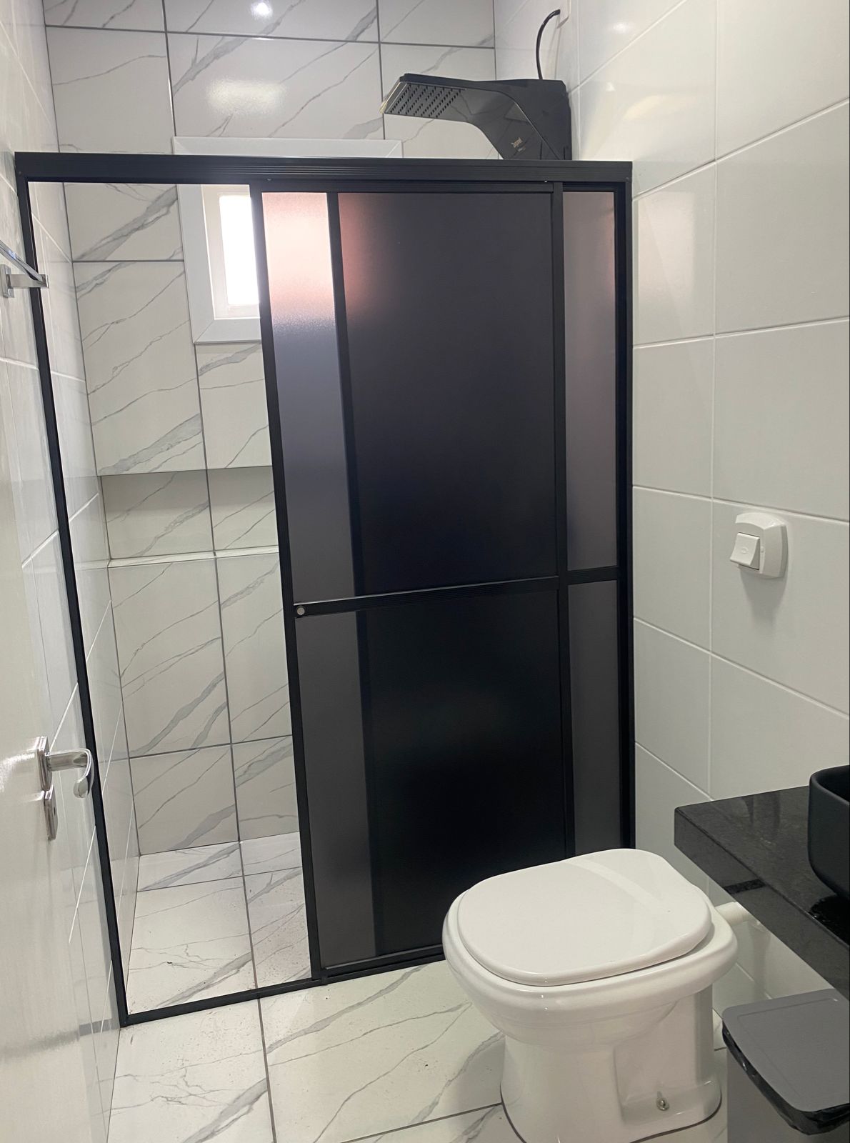 Box em acrílico preto instalado em banheiro moderno